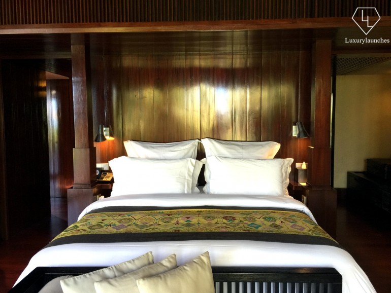 The master bedroom is furnished in dark bangkiray hardwood and woven fabrics — like the green bedspread pictured here