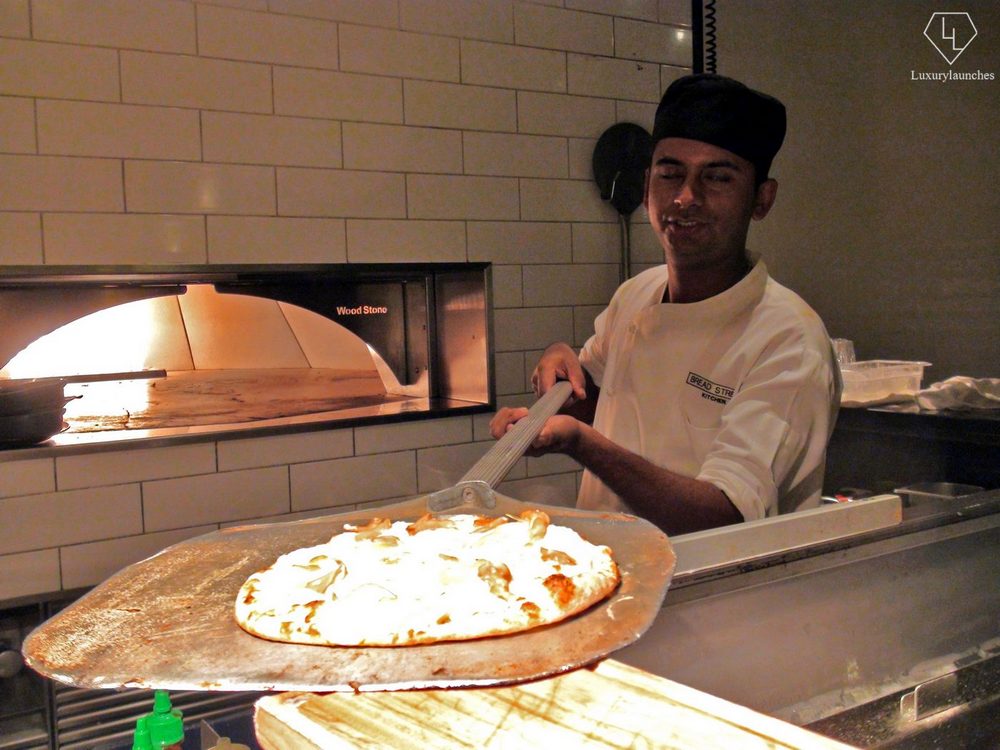 Showing off the freshly made vegetarian pizzetta retrieved from the pizza stone oven