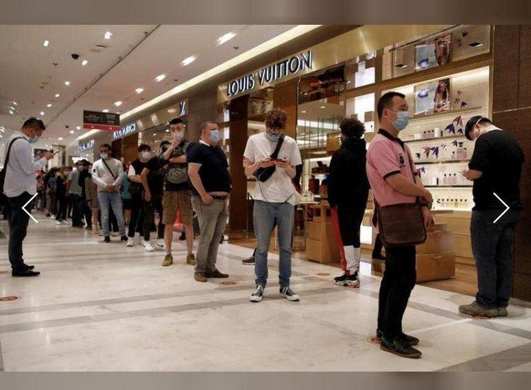 PARIS-APR 14: Customers are on queue to enter Louis Vuitton shop